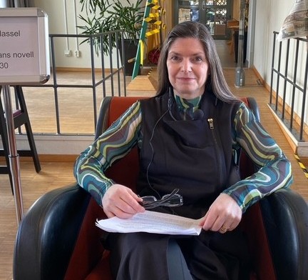 en kvinna sittandes i en fåtölj med en bok