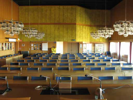 en stor sal med blåa stolar och glaskupoler till lampor