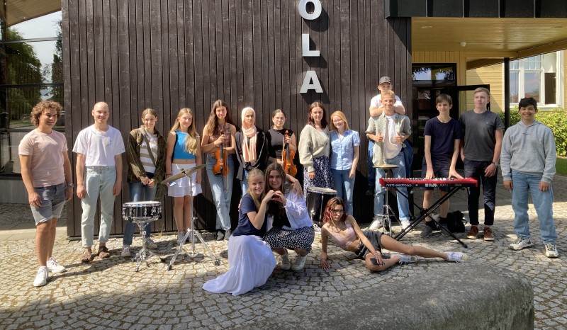 Sommarmusikanterna uppställda framför musikskolan tillsammans med ledarna. 