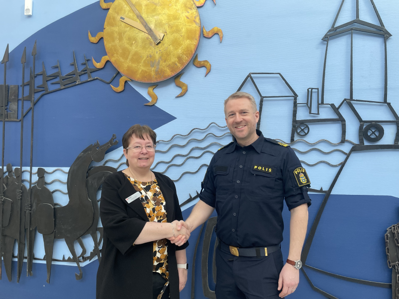 Socialchef Susanna Olsen skakar hand med lokalpolisområdeschef Anders Sund i kommunens ljushall.