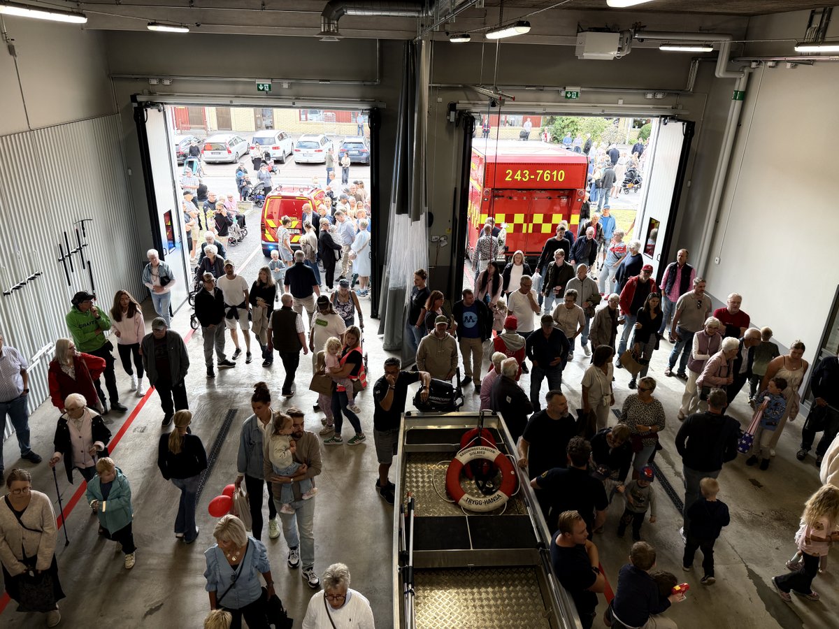 Helikoptervy över brandstationen invändigt. Massvis av nyfikna invånare går i lokalerna.