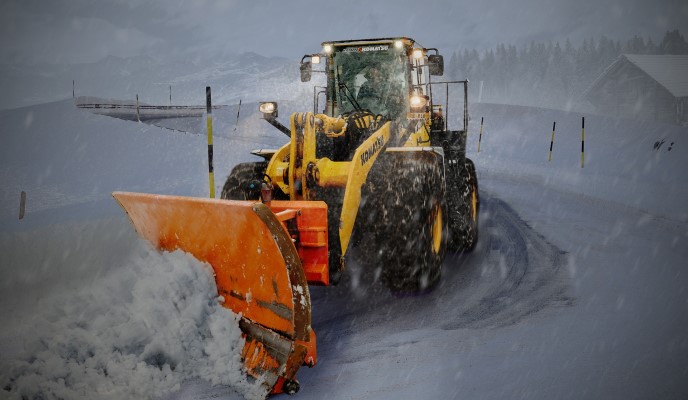 Gul snöplog som plogar snö.