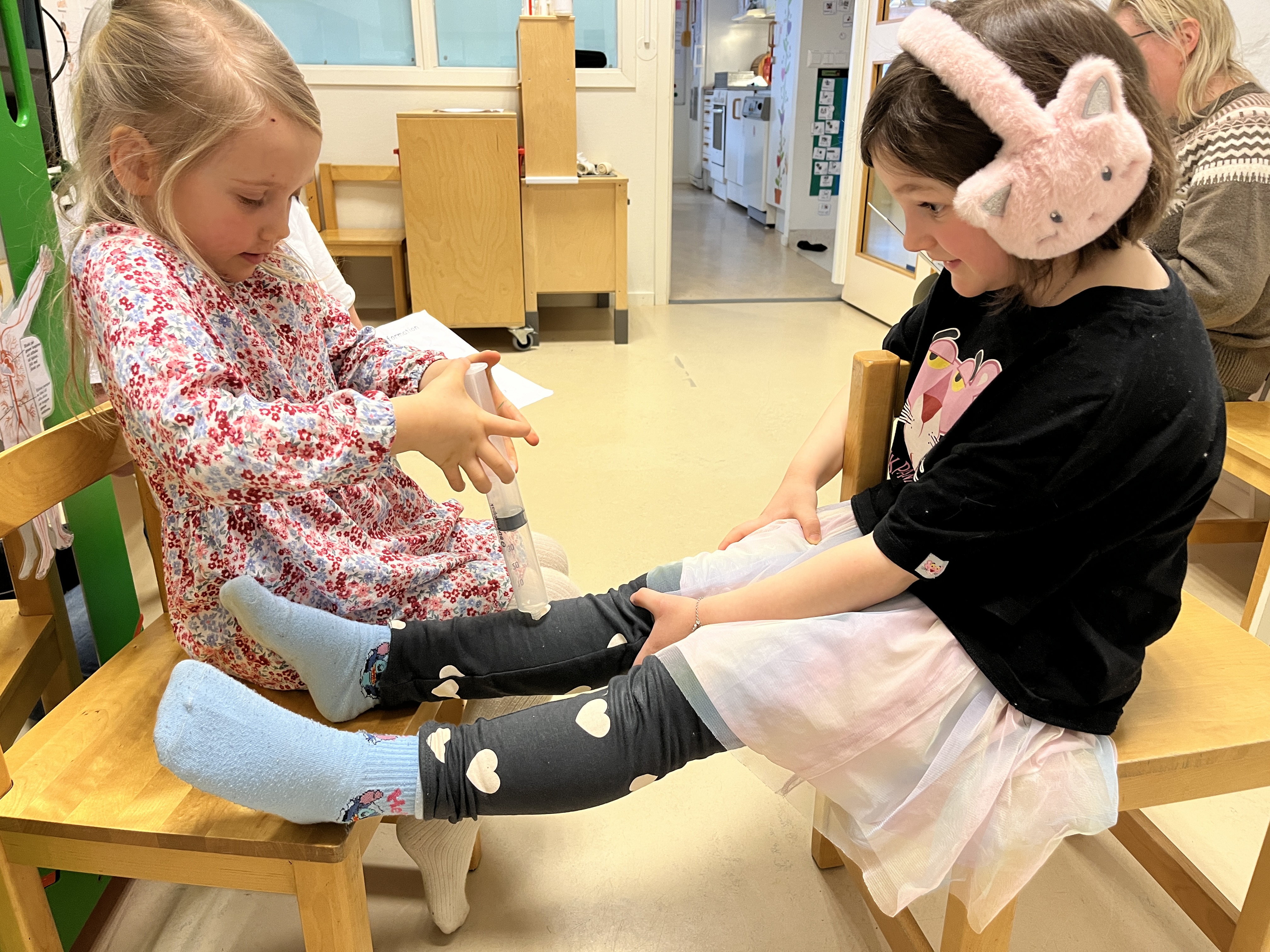 Foto på två flickor som leker doktor och patient.