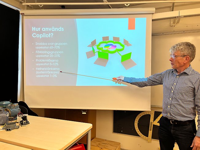 Foto på en man framför en tavla.
