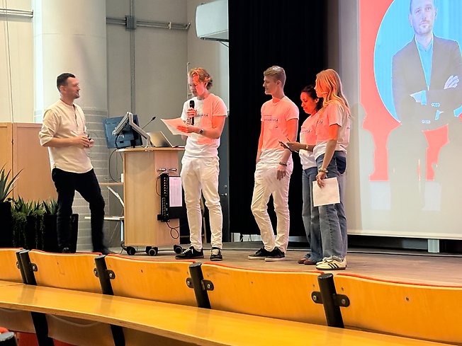 Foto på elever som intervjuar Adnan Dibriani på scen.