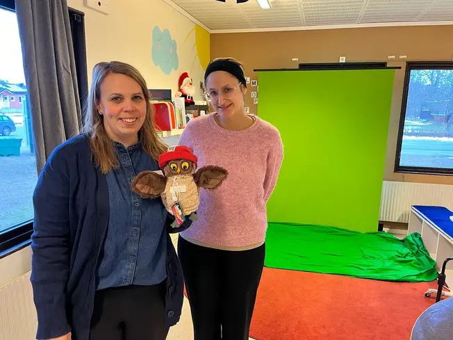 Foto på två kvinnor och handdockan.