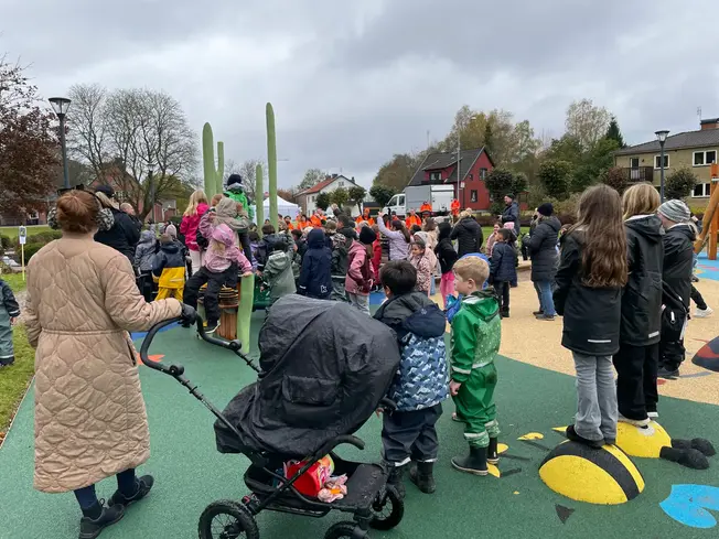 Ett myller av barn och vuxna på den nya lekplatsen.