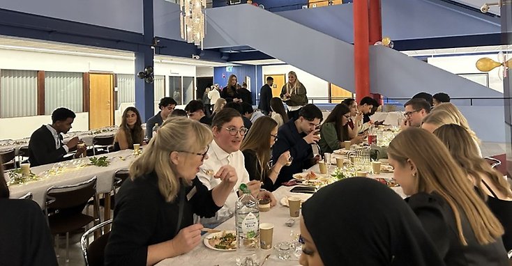 Foto på människor som sitter och äter en festmåltid.