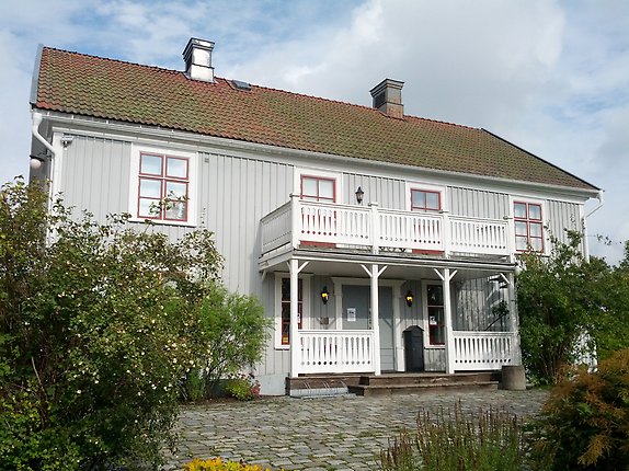 ett grått hus med vit veranda