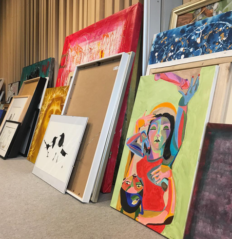 tavlor som står staplade mot en vägg