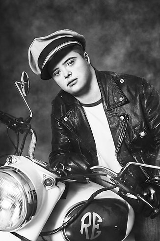 ett svartvitt foto av en kille på motorcykel