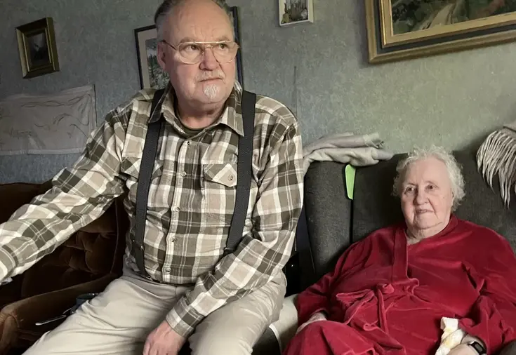 Ulf sitter på soffkanten, bredvid sin Mamma Gerd, 93 år. 