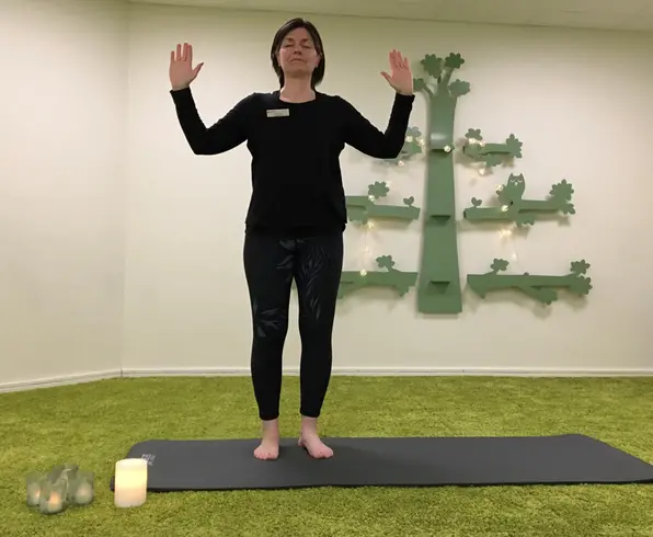 kvinna i yogarörelse på en yogamatta.