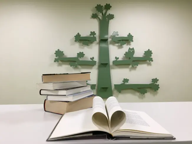 ett bokuppslag framför ett prydnadsträd på väggen