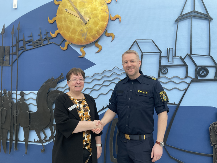Socialchef Susanna Olsen skakar hand med lokalpolisområdeschef Anders Sund i kommunens ljushall.