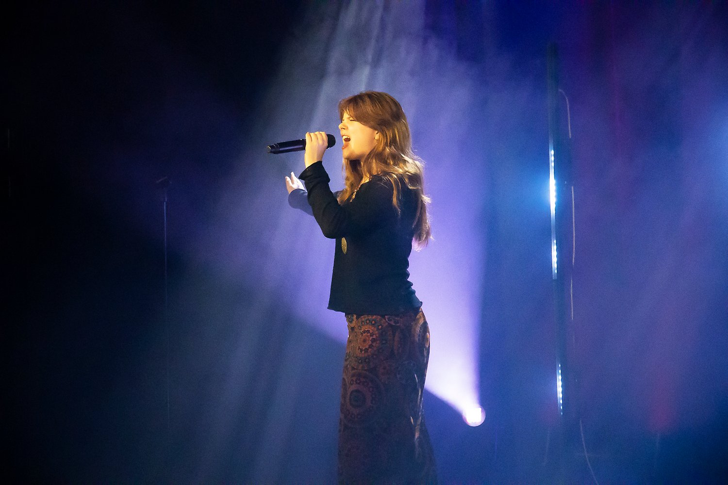 en ung kvinna som sjunger på en scen.