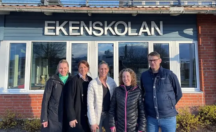 Fem personer framför Ekenskolan